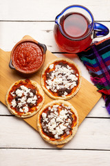 Mexican red sopes with cheese and beans on white background