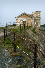 Old lighthouse in the fog on a rock. Gamow Lighthouse on the Gamow Peninsula. Dangerous Bay in the Sea of Japan. Far East.