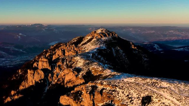 Aerial landscape view from the Ceahlau Mountains National Park and Toaca peak at sunset in the winter season. Aerial view from the drone