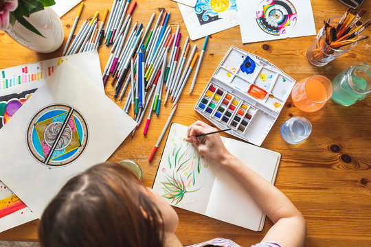 Woman painting with watercolours, top view