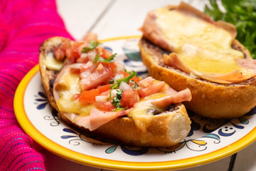 Mexican molletes with ham and cheese on white background