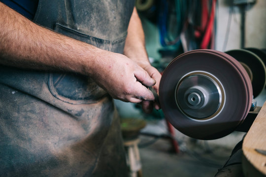 Craftsman making knives in his workshop