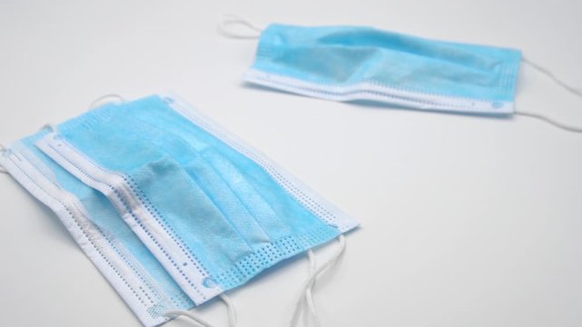 Slow motion of three surgical masks on white background. 