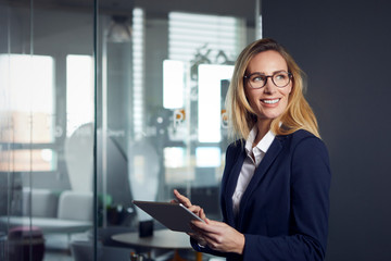 Smiling businesswoman using tablet in office