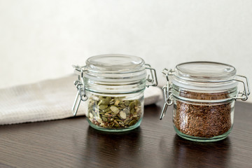 flax seeds in a jar with a lock on the table, pumpkin seeds in a jar with a lock on the table