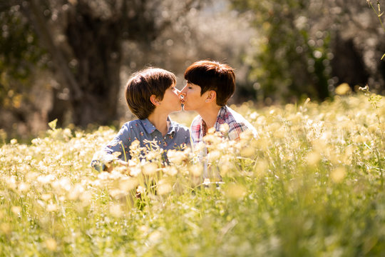 Mother and daughter kissing in a field of wildflowers