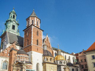 Fototapeta na wymiar Beautiful architecture and rooftops of Wawel Castle with blue sky in background.