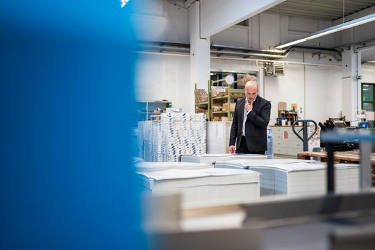 Businessman in a printing plant checking product