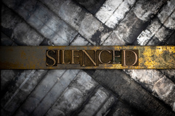 Photo of real authentic typeset letters forming Silenced text on vintage textured grunge copper and...