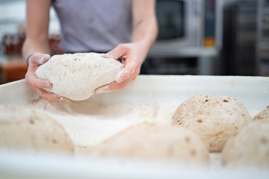 Close-up of woman preparing bread in bakery
