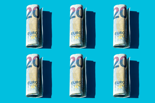 Twenty euro rolled banknotes pattern on a blue background