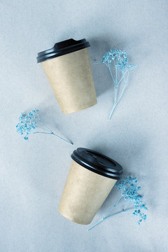 Disposable Paper Cups For Coffee And Blue Flowers. Takeaway Coffee Concept. View From Above.