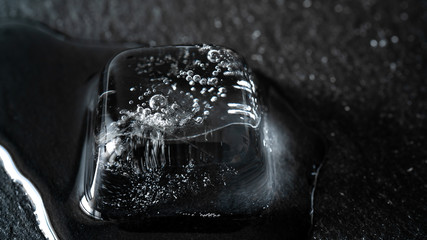 Close-up of melting ice cubes on black background