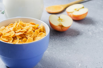 Corn flakes in a blue Cup and Apple slices. Useful Breakfast in the morning. Copy space