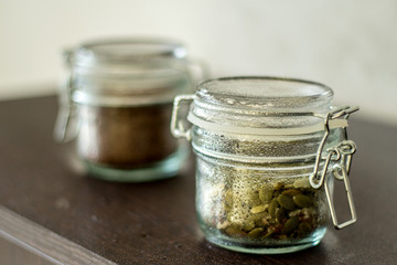 flax seeds in a jar with a lock on the table, pumpkin seeds in a jar with a lock on the table