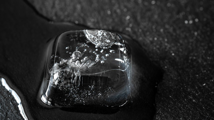 Close-up of melting ice cubes on black background