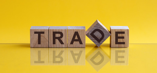 TRADE message word on a wooden desk on cube blocks with a green nature background