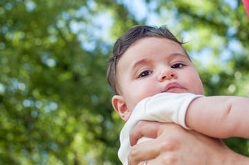 baby boy looking at the camera on a green bacground