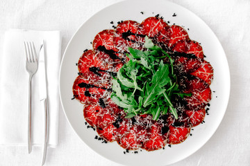 carpaccio with parmesan, balsamic vinegar on a plateau on the table top view