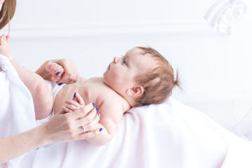 the child is in the hands of the mother. a three-month-old baby in mom's arms.