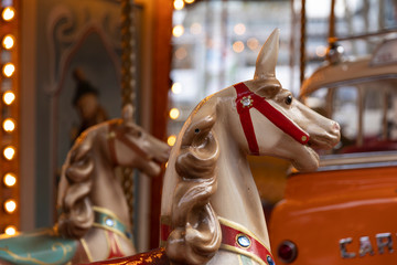 Fototapeta na wymiar A head of an old vintage horse carousel ride in the city center of Eindhoven, the Netherlands on the Markt, an authentic retro merry go round with lights