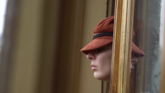 Woman at the window looking somewhere.