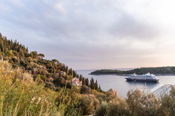 Obraz premium The view of the Adriatic sea with Lokrum island and a big cruise ship with tourists near Dubrovnik Old Town in Dalmatia on a sunny day in summer during sunset. Holiday destination, idyllic scenery