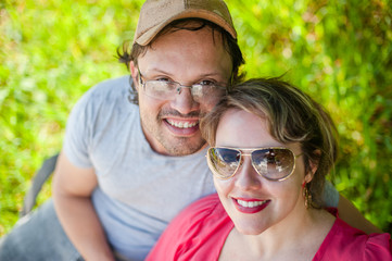 high angle view of a couple looking at the camera in a green background.