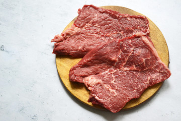 Tenderloin of fresh beef meat on a wooden board on a white background