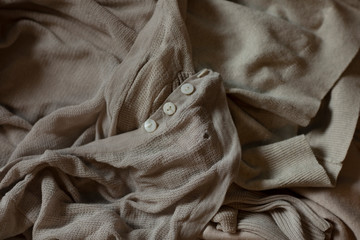 Old clothes in washed out colors laying on a pile. Different pieces with holes and stains ready to be recycled, circular economy principle. Fashion industry waste