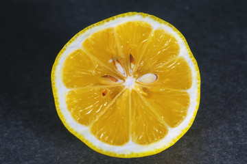 Sliced lemon isolate on a dark background close-up.