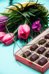 Candy box and tulips for the romantic gift on blue background, copy space, Chocolate candies in the box.