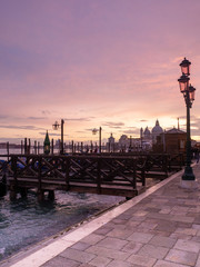 Obraz premium Pink sunset from San Marco square, Venice, Italy, with the gondolas and the Grand Canal in the background