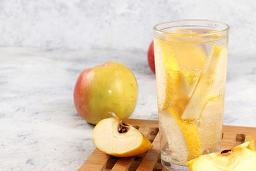 Apple cider, juice or fruit drink in a glass on a sunny table. A minimal concept of detox diet and...