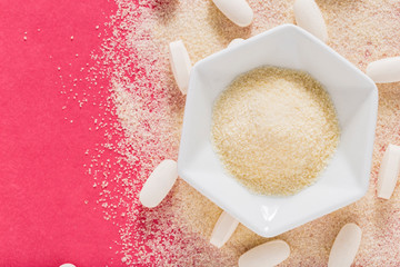 Hydrolyzed and co-compressed collagen, on pink background, top view