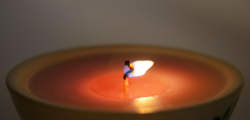 Burning candle wick close-up, macro. Festive, New Year's, green wax candle burns slowly against a...