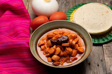 Mexican sausage with chipotle sauce on wooden background