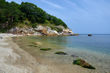 Sea coast with clear water. Sandy deserted wild beach.