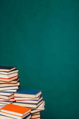 a lot of educational books for exams at the university on the green background of the library