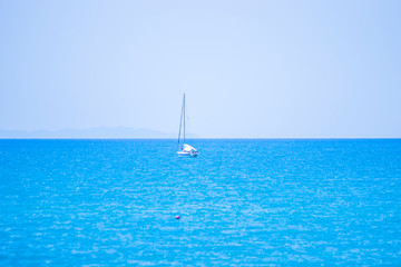 Fototapeta premium blue sea with white boat and island in the background