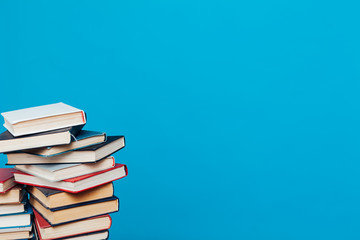 a lot of educational books for college exams on the blue background of the library