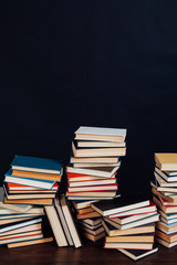 a lot of educational books for exams at the university on the black background of the library