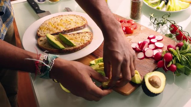 Top view person making healthy vegan tartine sandwich