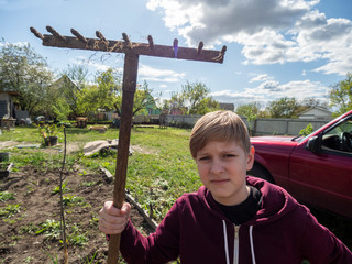 Caucasian boy posing with rake