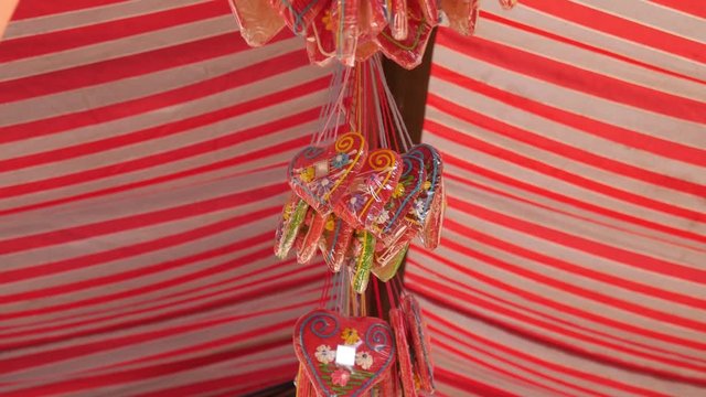 Licitars hearts. Gingerbread hearts hanging below the festivals red-and-white striped tent.