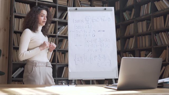 Young hispanic woman professional tutor teaching math class explaining remote course lesson. Latin female college teacher conferencing webcam zoom online video call virtual computer lecture concept.
