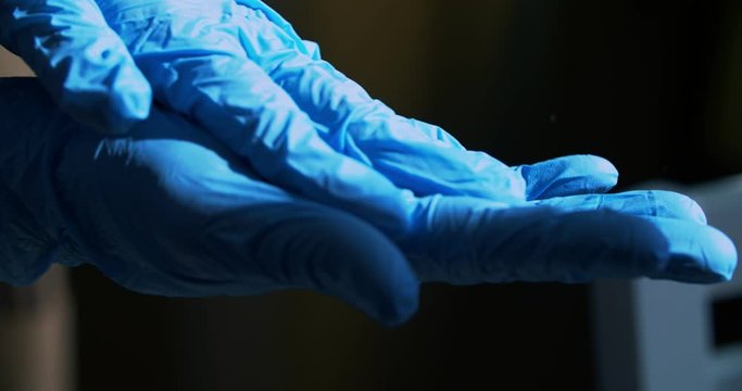 A paramedic in blue rubber gloves treats hands with an antiseptic from the virus. Disinfection of hands during a pandemic