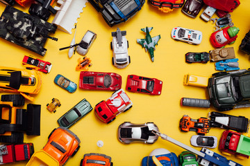 Lots of children's toy cars for child development games on a yellow background
