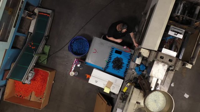 Aerial of employee working at Injection molding machine in manufacturing factory