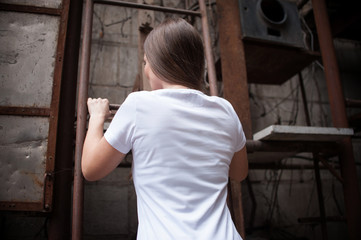 athletic brunette girl in a white t shirt climbs up the stairs